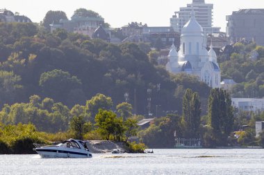 Ukrayna 'nın başkenti Kyiv' de geniş nehir kıyısındaki büyük şehrin parlak akşam manzarası. Vaftizci Kilisesi Barış Tapınağı.