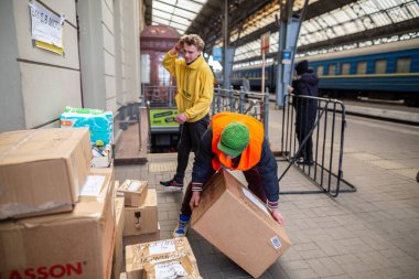 LVIV, UKRAINE - 12 Mart 2022: Ukrayna 'daki savaş sırasında insani kriz. Gönüllüler insani yardıma yardım için yardım ediyor. Binlerce mülteci savaştan zarar görmüş bölgelerini Lviv Tren İstasyonu 'na terk ediyor.