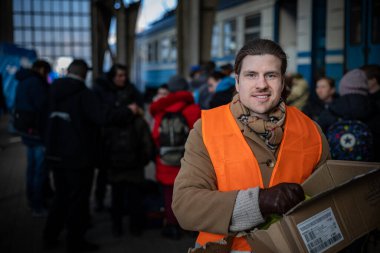 LVIV, UKRAINE - 14 Mart 2022 Ukrayna 'daki savaş sırasında insani yardım krizi. Binlerce mültecinin beslenmesine yardım eden gönüllüler savaştan zarar görmüş bölgeleri Lviv Tren İstasyonu 'ndaki Avrupa' ya kaçtılar..