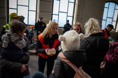 LVIV, UKRAINE - 14 Mart 2022 Ukrayna 'daki savaş sırasında insani yardım krizi. Binlerce mültecinin beslenmesine yardım eden gönüllüler savaştan zarar görmüş bölgeleri Lviv Tren İstasyonu 'ndaki Avrupa' ya kaçtılar..