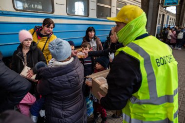 LVIV, UKRAINE - 14 Mart 2022 Ukrayna 'daki savaş sırasında insani yardım krizi. Binlerce mültecinin beslenmesine yardım eden gönüllüler savaştan zarar görmüş bölgeleri Lviv Tren İstasyonu 'ndaki Avrupa' ya kaçtılar..