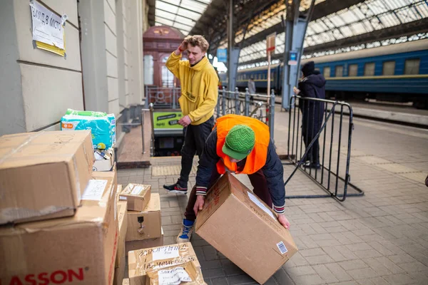 LVIV, UKRAINE - 12 Mart 2022: Ukrayna 'daki savaş sırasında insani kriz. Gönüllüler insani yardıma yardım için yardım ediyor. Binlerce mülteci savaştan zarar görmüş bölgelerini Lviv Tren İstasyonu 'na terk ediyor.