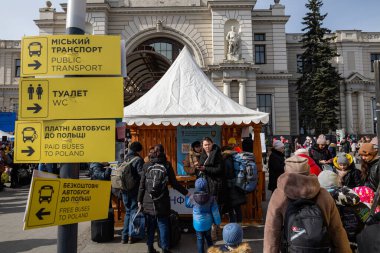 LVIV, UKRAINE - 12 Mart 2022 Ukrayna 'daki savaş sırasında insani yardım krizi. Bilgilerin alınmasına yardım eden gönüllüler binlerce mülteci savaştan zarar görmüş bölgeleri Lviv Tren İstasyonu 'ndaki Avrupa' ya kaçtılar..