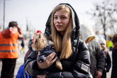 LVIV, UKRAINE - 12 Mart 2022 Ukrayna 'daki savaş sırasında insani yardım felaketi. Savaşın parçaladığı bölgelerden küçük bir köpeği olan mülteciler Lviv Tren İstasyonu 'ndaki Avrupa' ya kaçıyorlar..