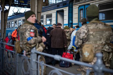 LVIV, UKRAINE - 12 Mart 2022 Ukrayna 'daki savaş sırasında insani yardım felaketi. Sınır muhafızları, küçük çocuklu mültecilerin belgelerini kontrol ediyor. Lviv Tren İstasyonu 'ndaki Avrupa' ya kaçıyorlar..