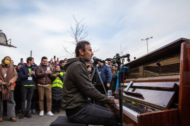 LVIV, UKRAINE - 12 Mart 2022: Okean Elzy Vyacheslav Vakarchuk 'un Lviv Tren İstasyonu' ndaki solistinin savaştan zarar görmüş bölgelerden gelen mültecileri desteklemek için verdiği spontane konser Avrupa 'ya kaçtı
