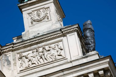 LVIV, UKRAINE - 21 Mart 2022: Lviv Ulusal Operası 'nın ön cephesindeki heykelleri olası bombalamalardan korumak için SES kurtarıcıları onları mineral yünü ve filmle sarmaladılar..