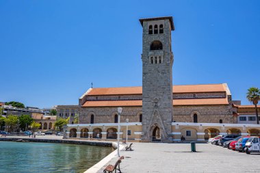 Rodos, Yunanistan - 4 Temmuz 2021: Mandraki limanı ve marinası. Rodos Heykeli 'nin yerine Bakire Meryem' in Anonsları Kilisesi. Eski kasabayı gezmek. Rodos, Yunanistan