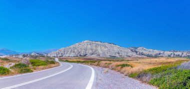 Yunanistan 'ın Rodos kentinde trafiği olmayan muhteşem yolların panoramik manzarası. Güzel asfalt otoyol, otoyol, güney manzarası boyunca otoyol temmuzun ortasında sıcak havada