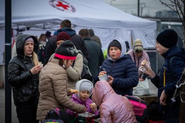 LVIV, UKRAINE - APR 02, 2022: Dünya Merkezi Mutfak ve Kızılhaç çadır kampında gönüllü olarak çalışan ve savaştan zarar görmüş binlerce mültecinin Lviv Tren İstasyonu 'ndaki Avrupa' ya kaçmasına yardım eden insanlar.