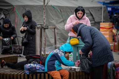 LVIV, UKRAINE - APR 02, 2022: Dünya Merkezi Mutfak ve Kızılhaç çadır kampında gönüllü olarak çalışan ve savaştan zarar görmüş binlerce mültecinin Lviv Tren İstasyonu 'ndaki Avrupa' ya kaçmasına yardım eden insanlar.