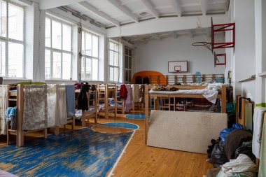 Obroshyne, LVIV, UKRAINE - APR 05, 2022: Okulun spor salonunda tahta ranzalar. Savaştan kaçan mülteciler için yaşam koşulları. Köy halkı tarafından zor zamanlar için sağlanan barınak..