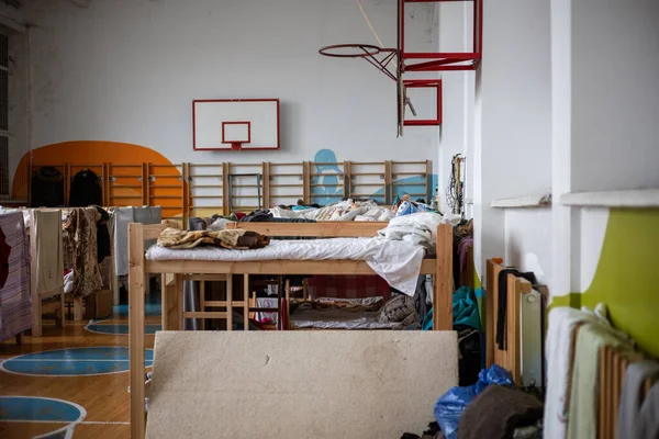 Obroshyne, LVIV, UKRAINE - APR 05, 2022: Okulun spor salonunda tahta ranzalar. Savaştan kaçan mülteciler için yaşam koşulları. Köy halkı tarafından zor zamanlar için sağlanan barınak..