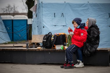 LVIV, UKRAINE - APR 02, 2022: Dünya Merkezi Mutfak ve Kızılhaç çadır kampında gönüllü olarak çalışan ve savaştan zarar görmüş binlerce mültecinin Lviv Tren İstasyonu 'ndaki Avrupa' ya kaçmasına yardım eden insanlar.