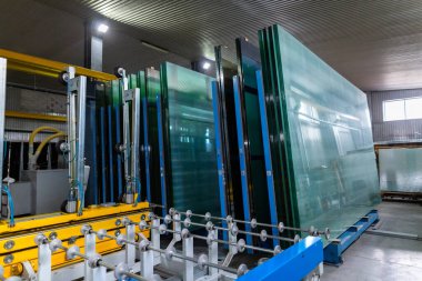 Cam levhadan yapılmış çift camlı pencere üretimi için bir fabrika. Cam levhalar cam kesme çizgisinin yanındaki paletlerde..
