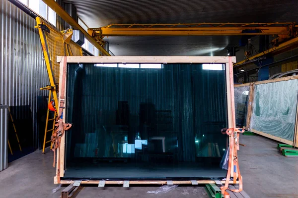 Factory for the production of double-glazed windows made of sheet glass. Sheet glass in pallets near the sheet glass cutting line.