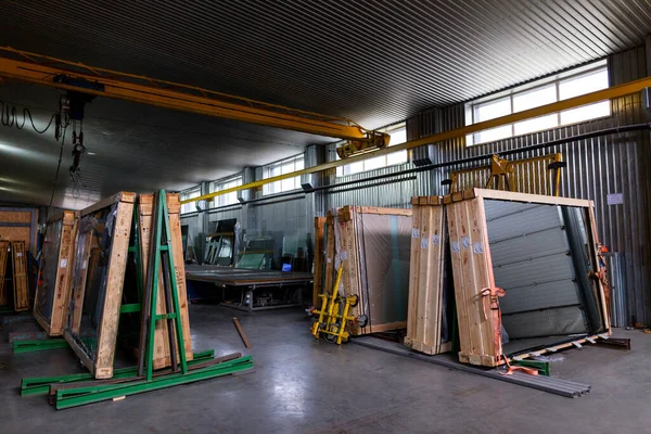 Factory for the production of double-glazed windows made of sheet glass. Sheet glass in pallets near the sheet glass cutting line.