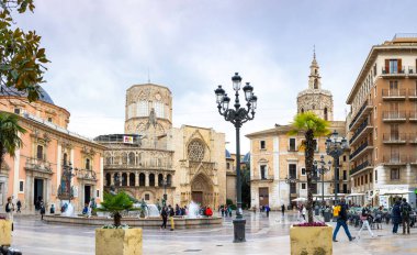 VALENCIA, SPAIN - 18 Nisan 2021: Valencia Katedral Tapınağı, Basilica de la nuestra senora de los desamparados ve Turia Fountain ile Aziz Meryem Meydanı 'nın panoramik manzarası