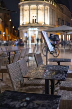 Tarihi bir şehir merkezinde geleneksel bir Fransız restoranının ya da kafenin boş bir alanı. Ziyaretçisi olmayan masa ve sandalyeler. HoReCa 'da iş. Masada bir yağmur damlası.