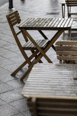 Tarihi bir şehir merkezinde geleneksel bir Fransız restoranının ya da kafenin boş bir alanı. Ziyaretçisi olmayan masa ve sandalyeler. HoReCa 'da iş. Masada bir yağmur damlası.