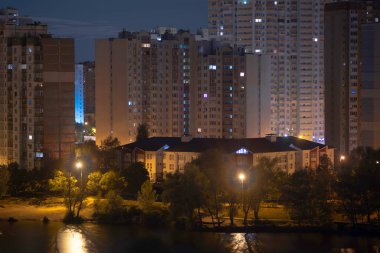 Büyük şehrin gece manzarası. Müthiş parlak, sokağa çıkma yasağında çok renkli ışık var. Yatak odası çevresindeki apartmanlar, banliyö bölgesi. Temmuz 2022 'de Kyiv. Ukrayna.