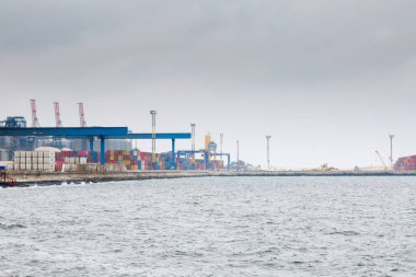 Odesa, Ukraine - OCT 21 2019: Autumn fog in the sea cargo port. Gantry cranes and other port infrastructure in the container terminal.