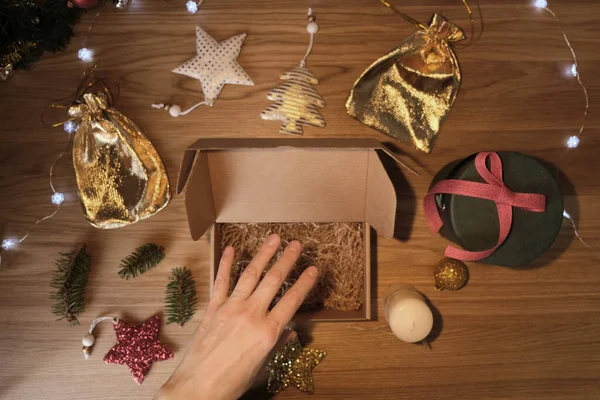 Le mani delle donne avvolgono un regalo di Natale in carta artigianale — Foto Stock