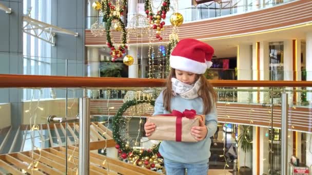 Happy girl in Santa hat with gift box — Stock Video