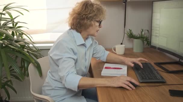 Attractive mature female architect designer in spectacles enjoying working process in office — 图库视频影像