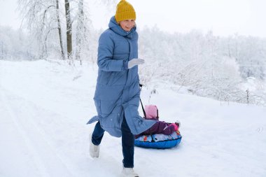 Sarı şapkalı ve mavi ceketli güzel bir son sınıf öğrencisi tepeden aşağı doğru koşuyor..