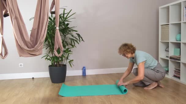 Senior hermosa mujer deportiva con gafas plegables estera para yoga — Vídeo de stock