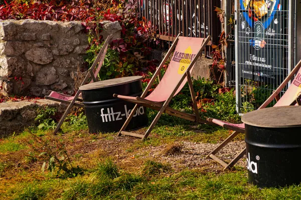 Avrupai bir caddede, insanların oturmadığı bir sokak kafesi grunge tarzı çatı katı çok renkli sandalyeler alışılmadık pencereler şık sandalyeler güneş şezlongları krakow kazimierz sarı kamyon renkli sandalyeler güneş altında sonbaharda dinleniyor