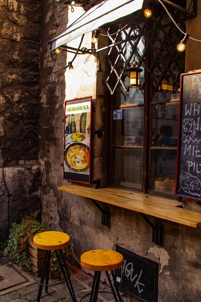 Avrupa 'da insanların olmadığı bir sokakta eski grunge tarzı çatı katı renkli sandalyeler alışılmadık pencereler şık sandalyeler güneş panjurları sıraları, krakow kazimierz siyah fare vücuduna boyanmış.