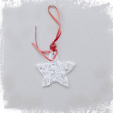 Işık çerçeveli kırmızı kurdeleli beyaz ipliklerden oluşan bir yıldız. Noel kartı. Noel süsü. Üst görünüm