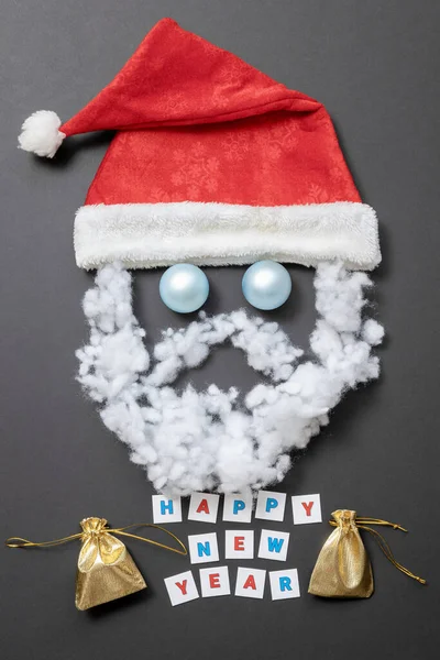 Roter Hut mit Weihnachtskugeln und Schnurrbart mit Bart aus Fiberfil. Lustiges Santas-Gesicht. Neujahrskarte — Stockfoto