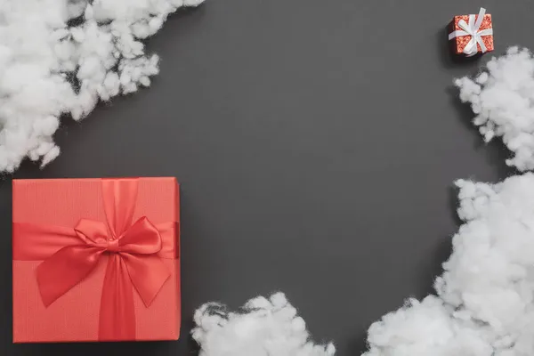 Samenstelling met twee rode geschenkdozen van verschillende afmetingen en een witte vezelvulling ertussen — Stockfoto