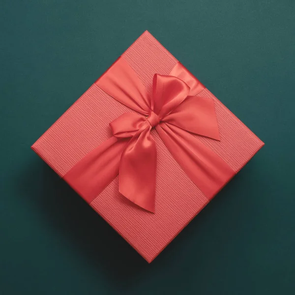 Rode doos met een strik op een smaragdgroene achtergrond. Bovenaanzicht. Aanwezig — Stockfoto