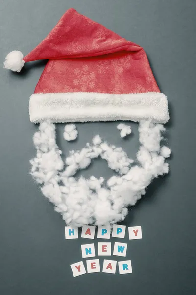 Roter Hut mit Schnurrbart und Bart aus Kunstfaser. Lustiges Santas-Gesicht. Neujahrskarte — Stockfoto