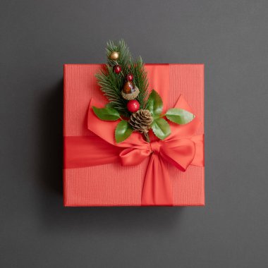 Dekoratif ladin dallı kare kırmızı hediye kutusu. Noel hediyesi.