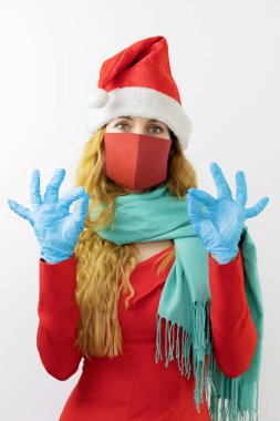 Koruyucu maskeli ve eldivenli Bayan Noel Baba iyi bir jest gösteriyor. Kutlama koruması. Korunmayla her şey yolunda.