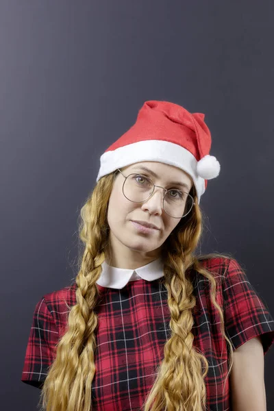 Porträt eines süßen Mädchens mit Weihnachtsmütze, Brille und zwei Zöpfen — Stockfoto