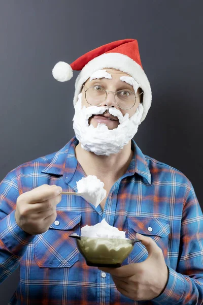 Überraschter Weihnachtsmann isst Eis, während er sich die Lippen leckt. Verkleidet als Weihnachtsmann. Köstliche Weihnachten. Frohe Weihnachten — Stockfoto