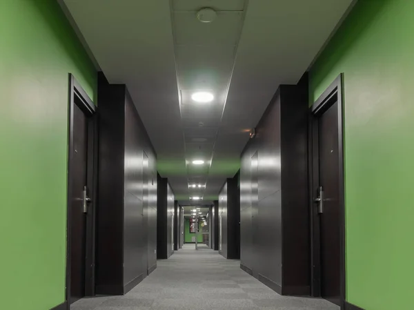 長い廊下だ。緑の壁、ドアの溶接材料とグレーのカーペット — ストック写真