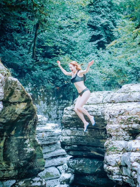 비키니를 입은 한 소녀가 비명을 지르며 협곡에서 물 속으로 날아갑니다. 야외 활동. 흰 절벽 협곡 — 스톡 사진