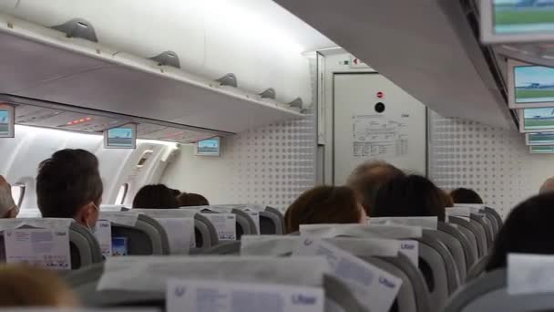 Rusia, Adler 02.11.2021. La cabina del avión con la gente antes del despegue. Publicidad en un monitor de diapositivas. — Vídeos de Stock