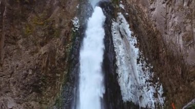 Yüksek bir uçurumdan büyük bir şelale akıntısı. Soğuk su, buzlu buz.