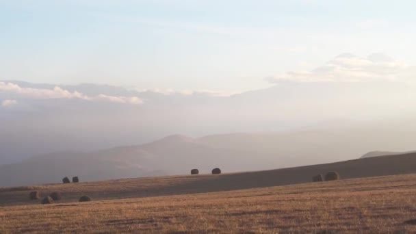 用干草卷和平顺的相机移动到块中的Elbrus山的大田. — 图库视频影像
