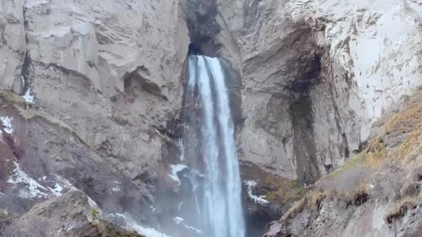 Wysoki wodospad spływa z jaskini skały u podnóża Elbrus. Pojęcie turystyki i rekreacji — Wideo stockowe