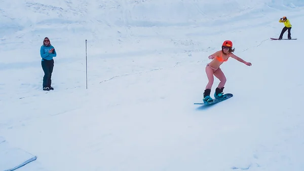 Rusko, Soči 11.05.2019. Dívka v plavkách nabírá rychlost na snowboardu a je vyfocena zezadu. Krasnaya Polyana — Stock fotografie