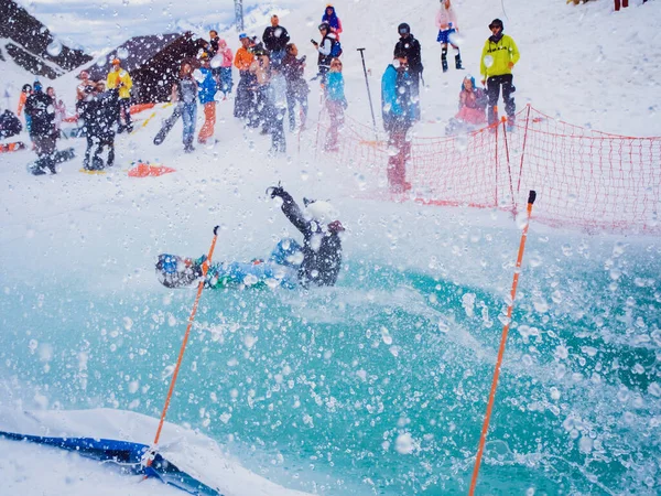 Rusko, Soči 11.05.2019. Chlápek se snowboardistou spadne do bazénu vysokou rychlostí a spousta šplouchnutí letí všemi směry, lidé se vzdalují, takže se na ně nedostane žádná voda. Krasnaya Polyana — Stock fotografie